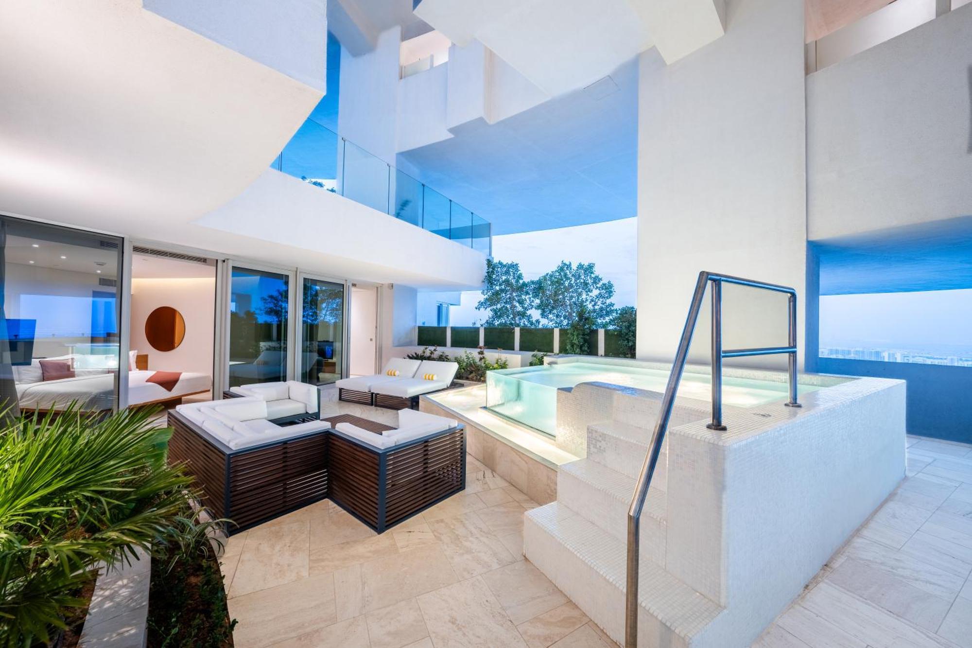 Five Jumeirah Village ดูไบ ภายนอก รูปภาพ The photo shows a modern and stylish outdoor area that appears to be part of a contemporary residence. It features a seating arrangement with a lounge set made of dark wood and cushions, providing a comfortable space for relaxation. Nearby, there is 